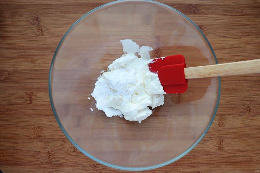 Пока кексы пекутся, приготовьте топпинг из сливочного сыра. Добавьте в него сахарную пудру и перемешайте до однородности. 