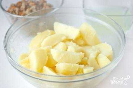 Очищенный и порезанный дольками картофель положите в кастрюлю, залейте холодной водой и посолите. Слейте воду, когда картофель будет полностью готов, и дайте картофелю остыть. 