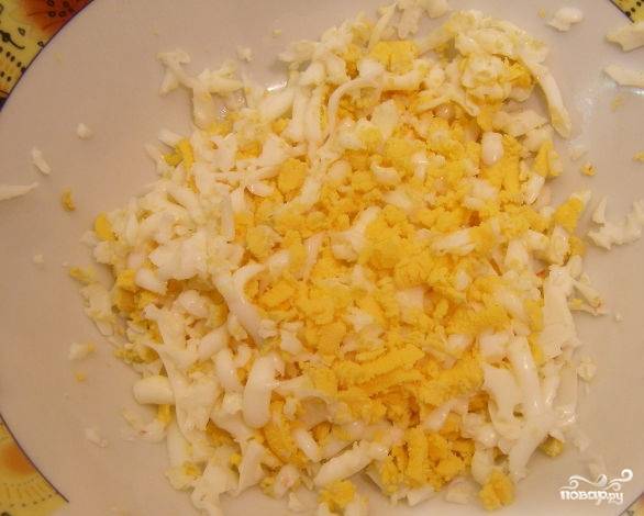 Варёные яйца остыдите, почистите и натрите на крупной тёрке.