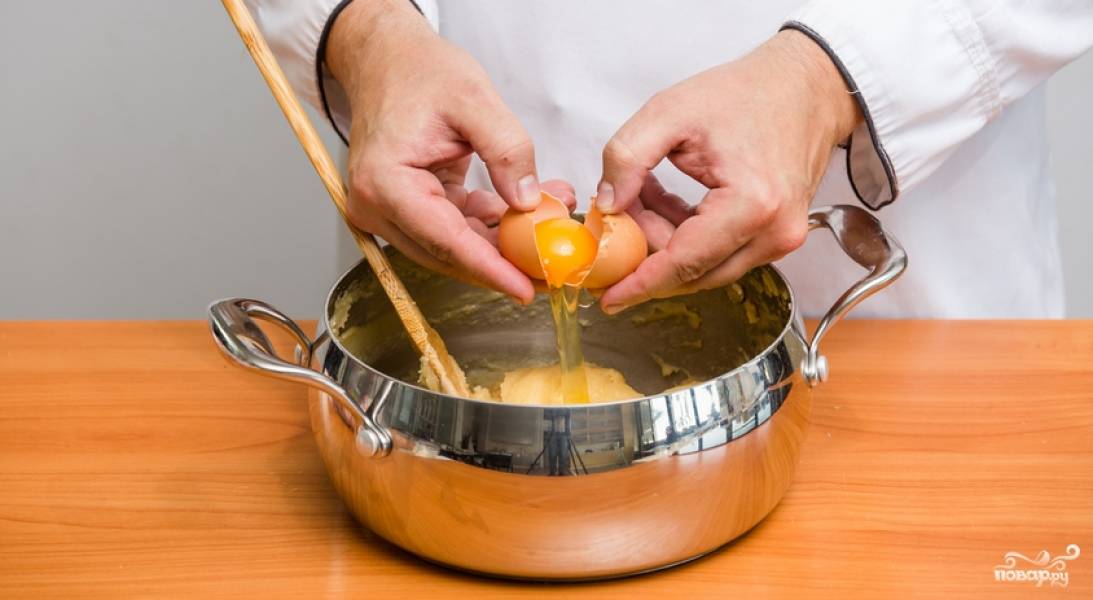 Остудите тесто (оно должно быть тёплым) и вбейте в него яйца (по одному). Каждое яйцо тщательно вмешиваем в тесто.