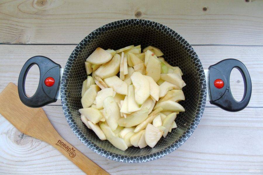 Выложите нарезанные яблоки в кастрюлю с толстым дном или антипригарным покрытием.