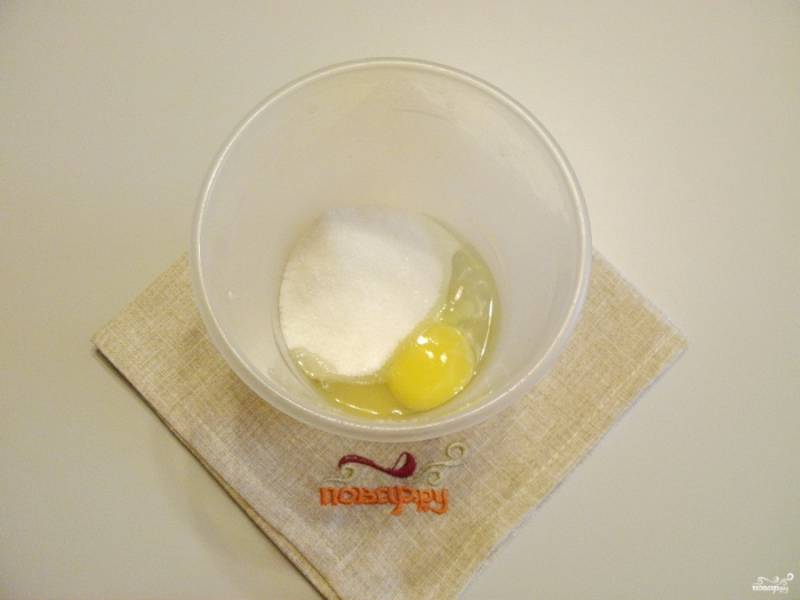 Возьмите удобную глубокую тару для взбивания. Можно воспользоваться венчиком или миксером. Взбейте яйцо с сахаром до пышной пены.