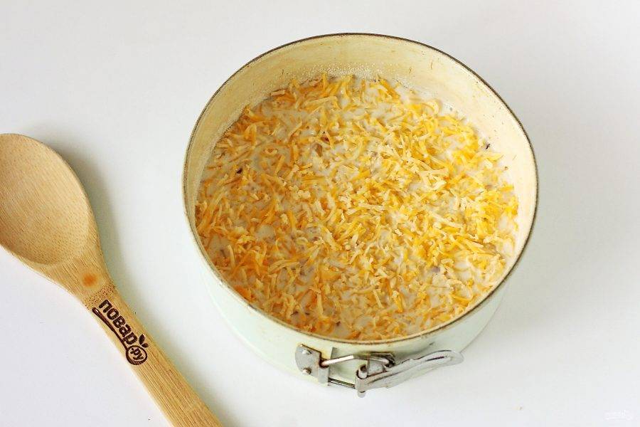 Сверху распределите оставшееся тесто и посыпьте все сыром. Запекайте в духовке при температуре 180 градусов около 30 минут.