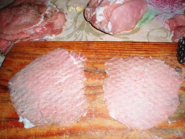 Для начала мы нарезаем наше мясо на порционные куски шириной чуть меньше сантиметра. Затем хорошенько их отбиваем, чтобы они стали довольно тонкими, обтираем их солью и черным молотым перцем.