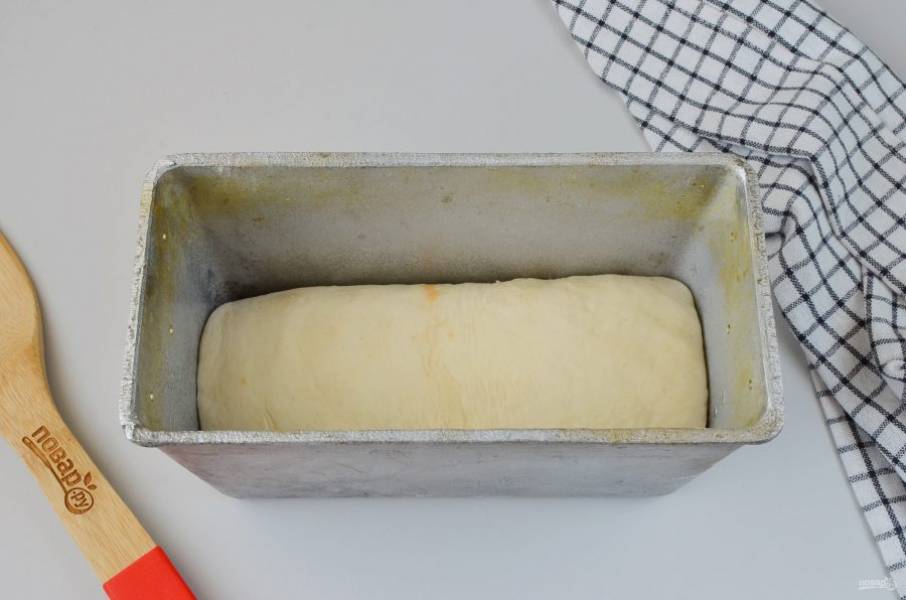 Форму для хлеба смажьте растительным маслом. Выложите хлебный рулончик. Накройте пленкой и уберите в тепло на 35-40 минут.