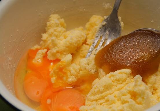 В глубокой емкости разминаем со стаканом сахара маргарин, также добавляем мед и яйца.