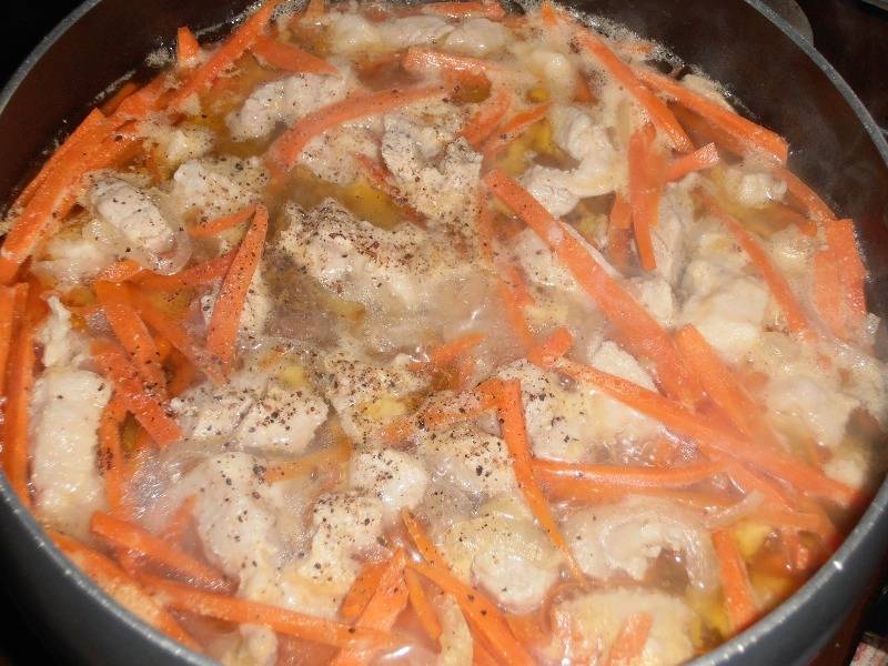 После этого добавляем морковь и заливаем мясо с овощами 1 литром воды. Солим все (примерно 2 чайные ложки) и приправляем специями, накрываем кастрюлю крышкой и тушим мясо на медленном огне в течение часа. 