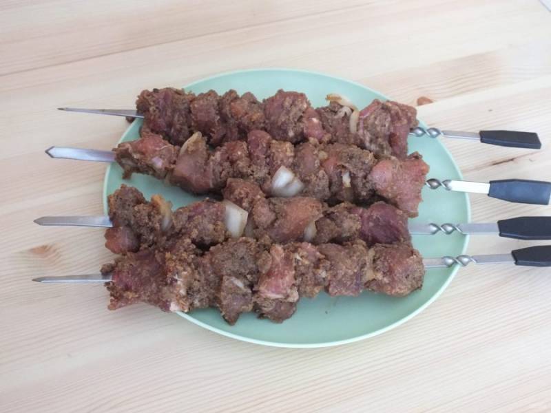 По окончании маринования, мясо насадите на шампуры, чередуя с луковыми четвертинками.
