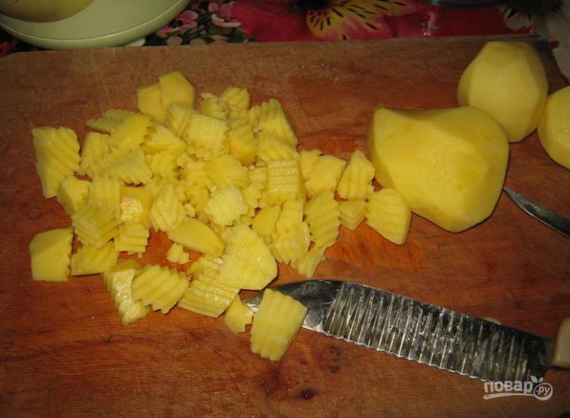 Картофель почистите, помойте и нарежьте кубиками. Доведите воду в кастрюле до кипения. Добавьте в неё картофель. Варите на среднем огне.