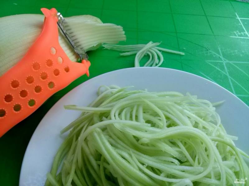 С помощью специальной терки для корейской моркови натрите кабачок. Из него нужно сделать тонкую длинную соломку, "спагетти". На этом этапе не добавляйте соль, чтобы кабачок не пустил раньше времени сок.