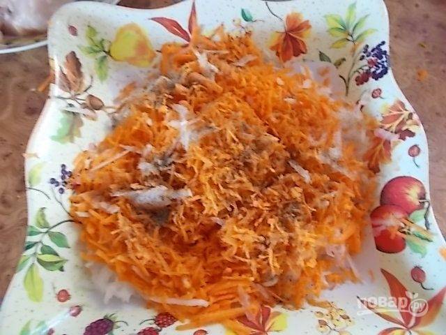 На терке такого же размера натираем морковь. Добавляем соль и молотый перец. Если делаете салат к обеду, можно добавить зубчик измельченного чеснока.