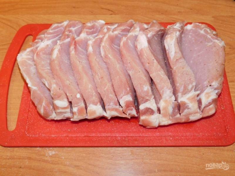 Возьмите кусок свинины без костей. Сделайте прорези по всему куску, не доходя до конца. Посыпьте мясо со всех сторон солью и специями.