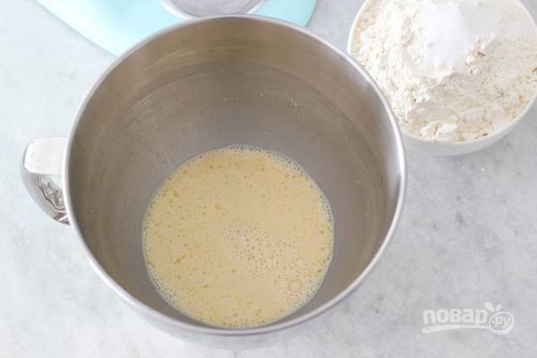 1. В глубокую емкость, для начала, вбейте яйцо и желток. Взбейте их с сахаром. Затем добавьте дрожжи, воду и теплое молоко. Перемешайте.