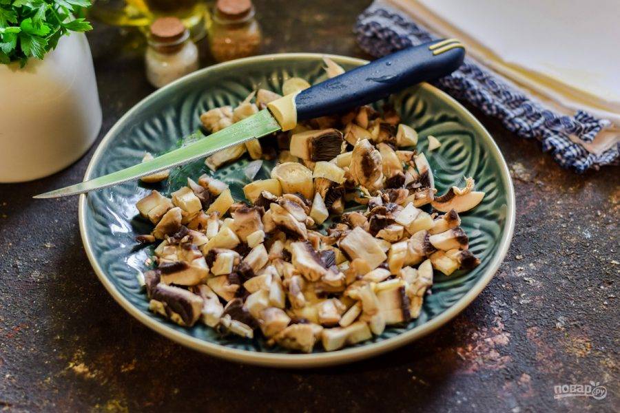 Грибы сполосните и просушите, нарежьте мелко. Поджарьте грибы на небольшом количестве растительного масла — 5-7 минут.