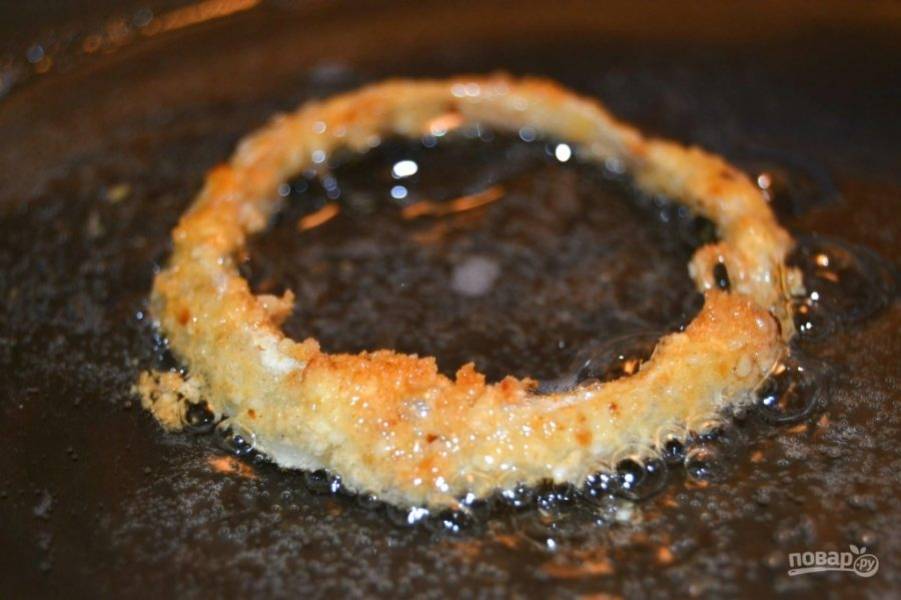 8.	Разогрейте сковороду с большим количеством оливкового масла, поместите луковые кольца в сковороду. Обжаривайте их до золотистого цвета.