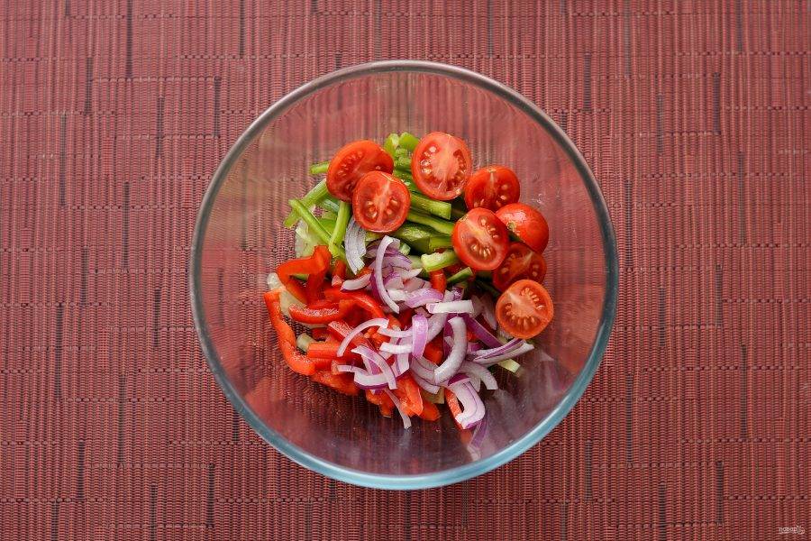 Для начала подготовьте овощи. Нарежьте болгарский перец, огурец и четвертинку красного лука соломкой. Помидоры черри разрежьте пополам. 