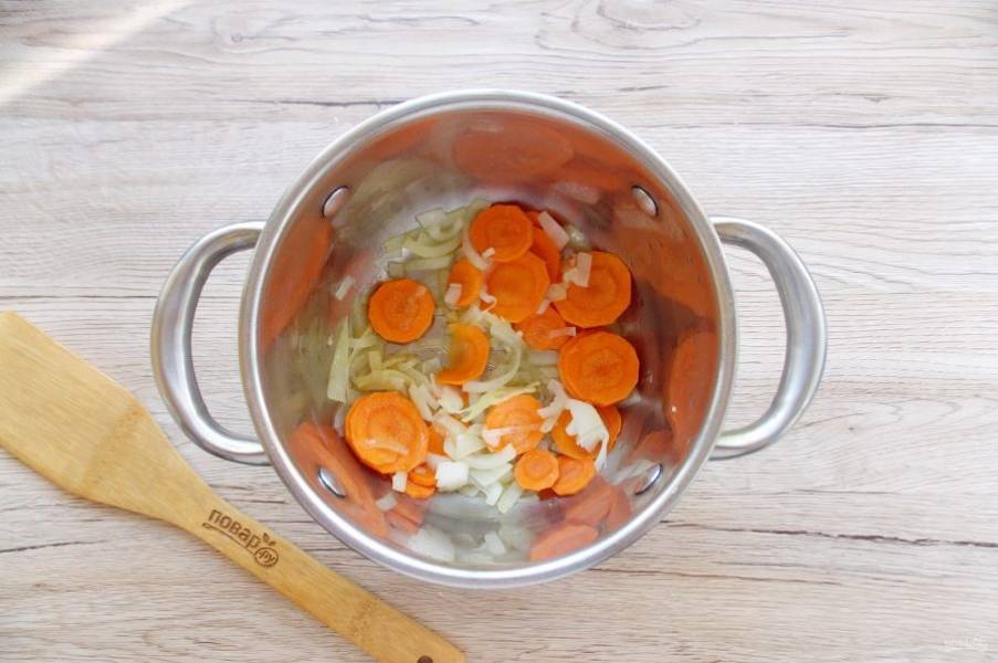 Морковь и лук очистите, помойте и нарежьте произвольно. Выложите в кастрюлю. Налейте подсолнечное масло и поджарьте до прозрачности лука.