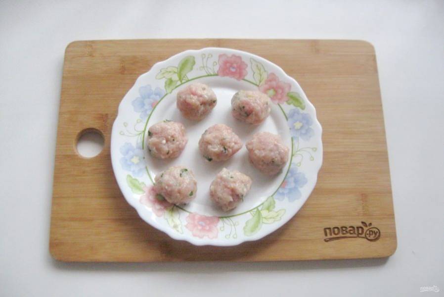 Мясной фарш посолите по вкусу, добавьте зелень. Сформируйте маленькие шарики — фрикадельки.