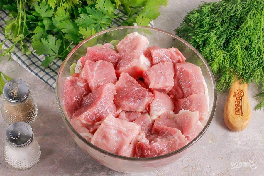 Нарежьте свинину порционными кусочками: крупно или мелко. Выложите в глубокую емкость.
