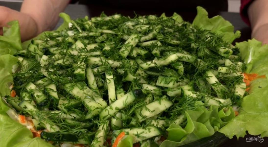5.  Последним слоем выложите огурец с укропом. Отправьте салат в холодильник на 1 час, после чего подсолите последний слой и подавайте. Приятного аппетита!