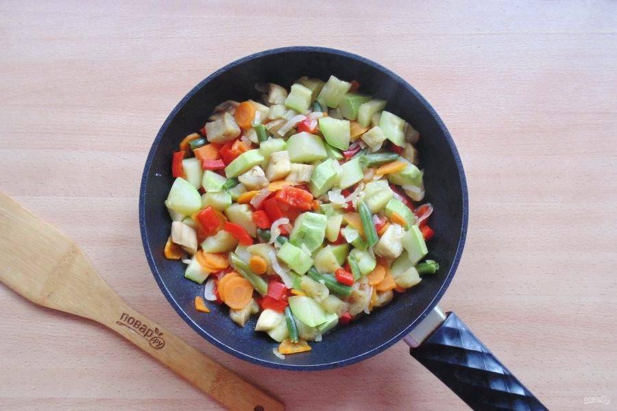 Накройте сковороду крышкой и тушите кабачок с овощами и перцем 10-15 минут до готовности.
