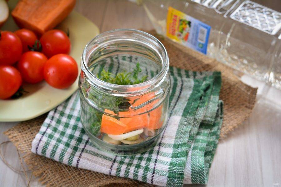 На дно стерилизованной банки выложите специи и овощи. Сложите вымытые веточки укропа, очищенные зубки чеснока, кольца репчатого лука и морковки. Добавьте перец горошком.
