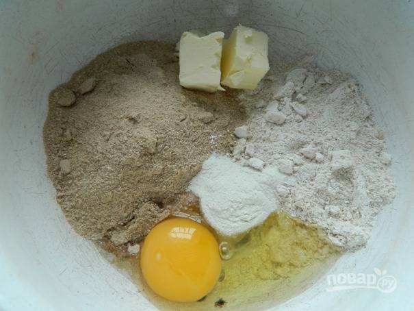 2. Затем добавляем в муку масло, мед, разрыхлитель и яйцо.
