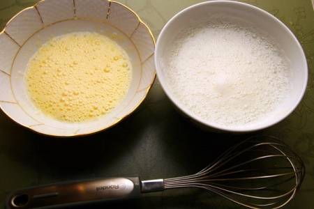 Приготовьте еще 2 миски. Разбейте яйца, отделите желтки от белков, взбейте по отдельности. К белку добавьте щепотку соли. 