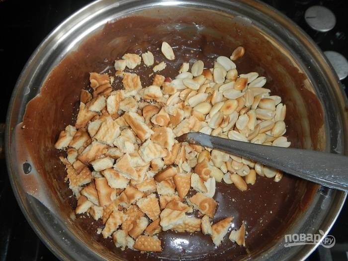 Затем туда же добавьте орешки и поломайте печенье.