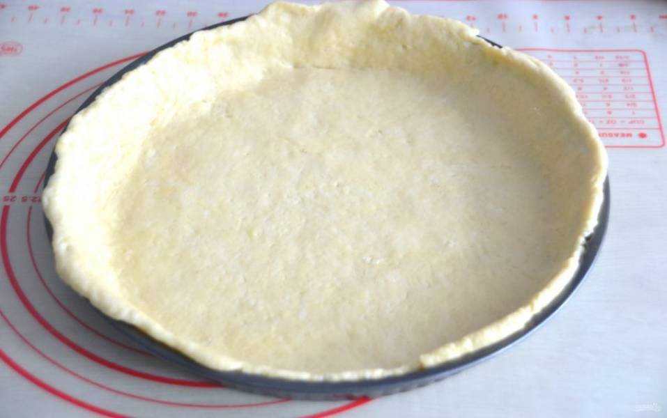 Выложите пласт теста в форму, предварительно смазанную растительным маслом. Должны остаться свободные концы, для того, чтобы окончательно закрыть пирог.