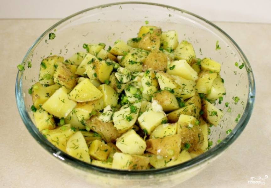 Выложите картофель в миску, полейте его готовой смесью из трав, хорошенько перемешайте и выложите на противень. 