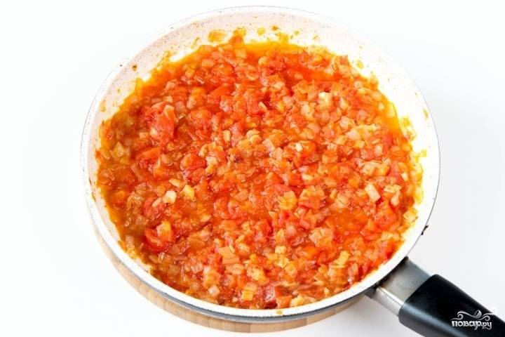 Выложите томаты в сковороду к луку. Перемешайте и тушите до мягкости около 8 минут.