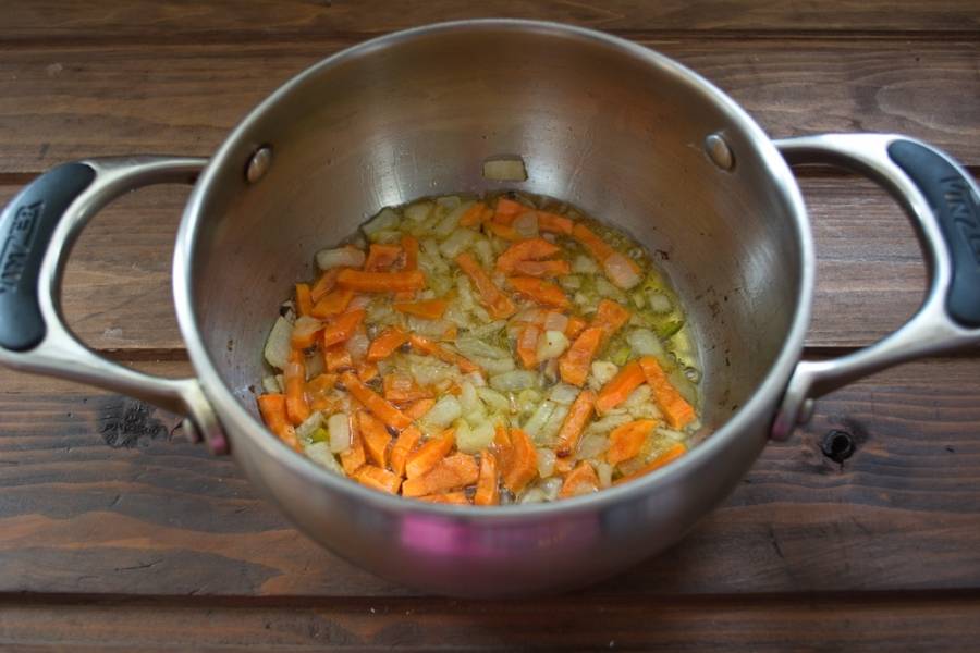 К обжаренному луку добавить нарезанную морковь. Обжарить вместе.