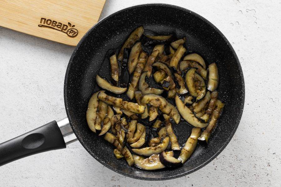 Обжарьте баклажаны в разогретой сковороде с растительным маслом до золотистого цвета.