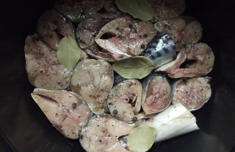 Переложите рыбу в чашу мультиварки, добавьте перец, соль и лавровые листы. Далее скумбрия будет готовиться в собственном соку. Выставляем режим "Тушение" на 1 час.