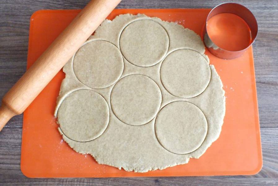 Раскатайте тесто в пласт толщиной 0,3 см. Вырежьте формой круги с диаметром 9 см.
