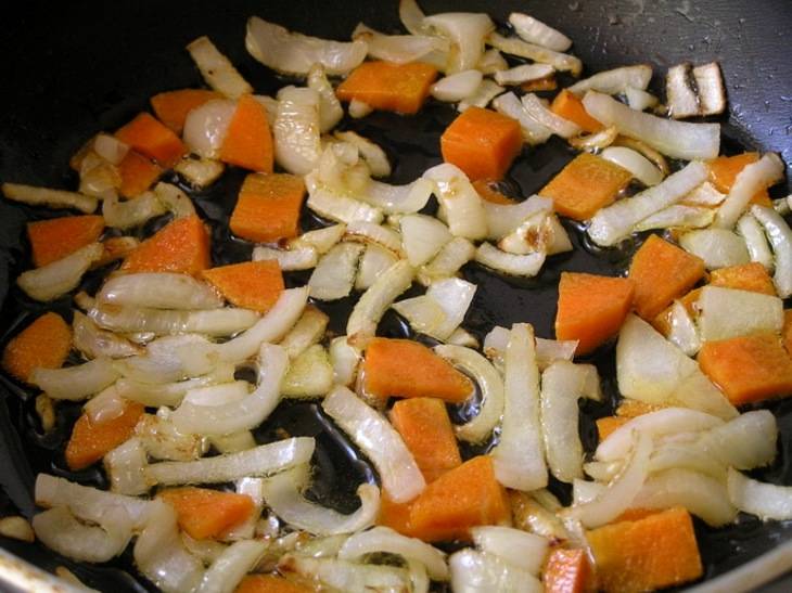 Для начала нарезаем репчатый лук на четвертькольца, морковь трем на крупной терке или нарезаем произвольно. Выкладываем овощи на разогретую сковородку и обжариваем до мягкости.
