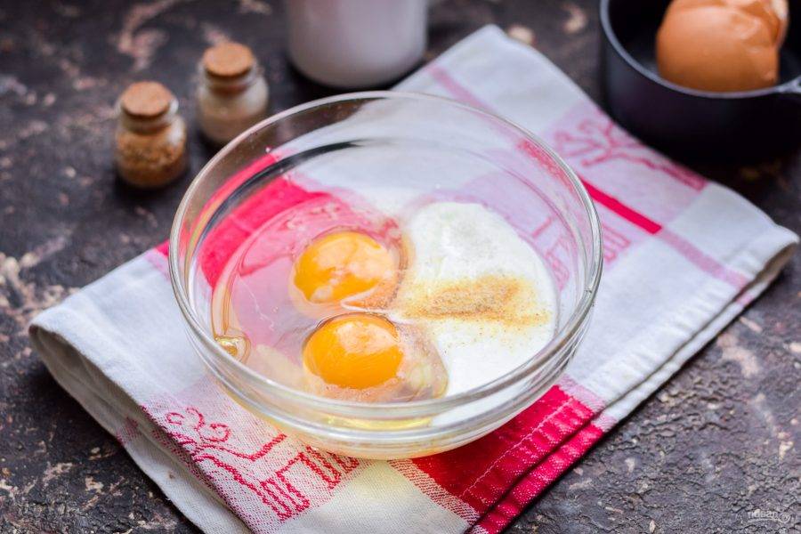 В миску вбейте несколько куриных яиц и добавьте йогурт. 