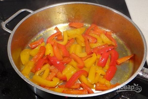 Почистите перцы и нарежьте их полосками размером с пенне. Нагрейте оливковое масло в глубокой сковороде на сильном огне, добавьте болгарский перец, острый перец, приправьте солью, свежемолотым черным перцем и обжаривайте в течение минуты, чтобы перец покрылся маслом.
