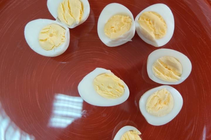 Отваренные в крутую перепелиные яйца разрезаем пополам.