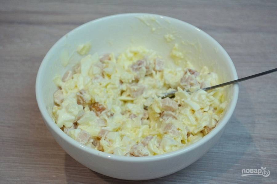 Сыр, мясо и яйца поместите в салатник. Заправьте майонезом. Добавьте немного молотого черного перчика. Перемешайте.