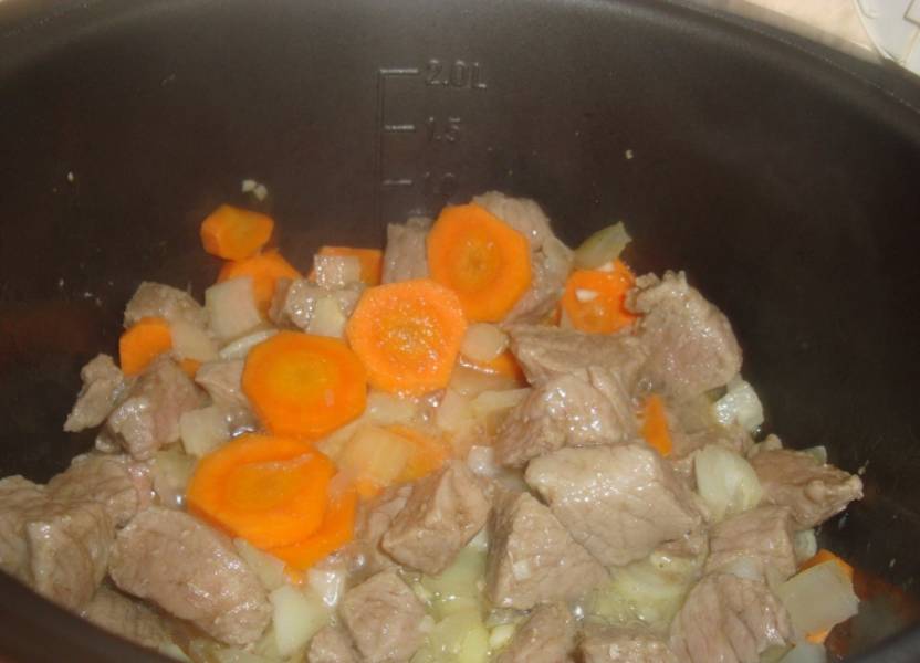 Через 10 минут, перемешайте мясо и добавьте к нему лук и морковь..