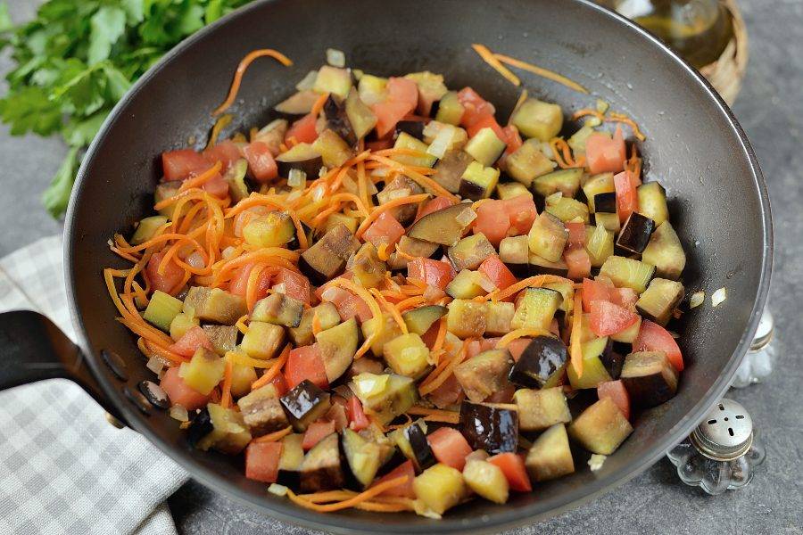 Баклажан и помидор нарежьте небольшим кубиком, добавьте в сковороду, влейте немножко воды и тушите под крышкой минут 5-7.