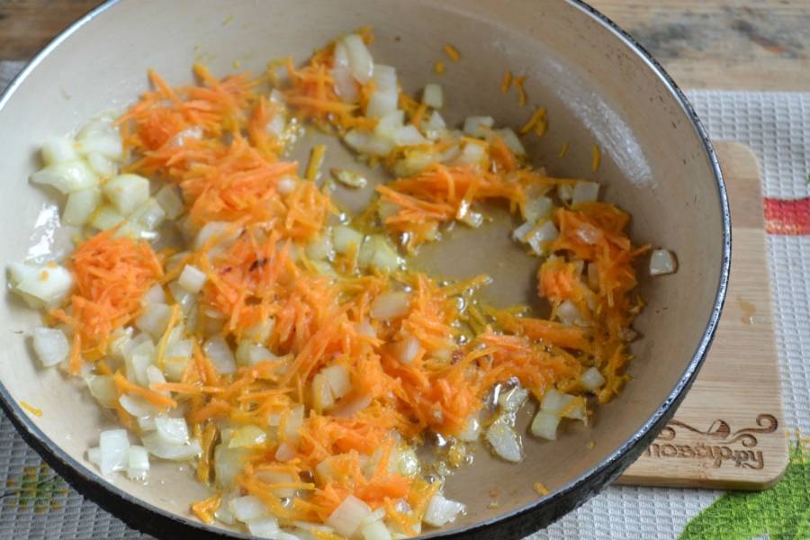 4. Лук очистите от шелухи и нарежьте кубиками. Очищенную морковь натрите на терке. Обжарьте их в растительном масле до мягкости. Затем перемешайте с подготовленным свиным фаршем, добавьте соль. 