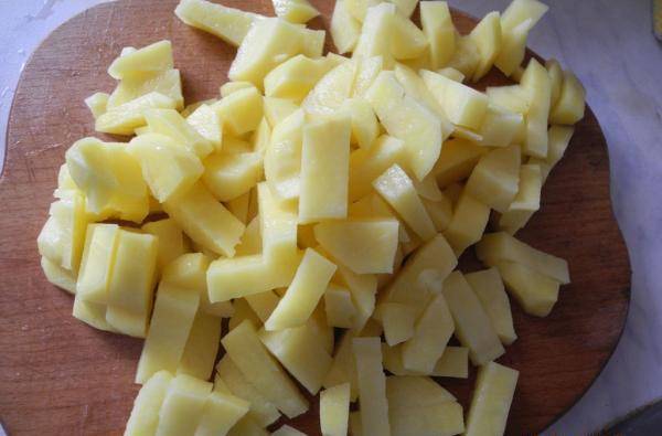 Картофель почистите и помойте. Нарежьте его брусочками и забросьте в бульон.
