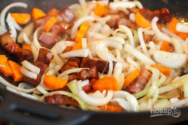 3. Пока обжаривается бекон, очистите и измельчите лук и морковь. Добавьте овощи на сковороду. 