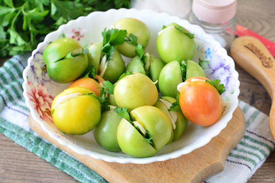 Нафаршируйте помидоры листочками петрушки и чесноком.