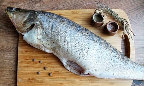 Рыбу выпотрошите, удалите плавники и жабры. Промойте тушку, а затем натрите её солью и перцем.