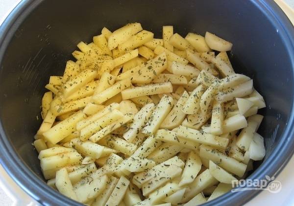 2. Картофель очистите и нарежьте. Выложите в глубокую мисочку, добавьте соль и специи по вкусу. Все как следует перемешайте и только потом выложите в чашу. 