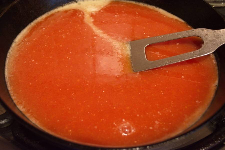 Влейте томатный сок. Быстро перемешайте. Когда жидкость начнет кипеть, помешивайте и варите до полного загустения. Разбивайте комочки, если таковые образуются.